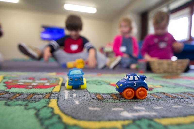 Des enfants jouent sur un tapis dans une crèche