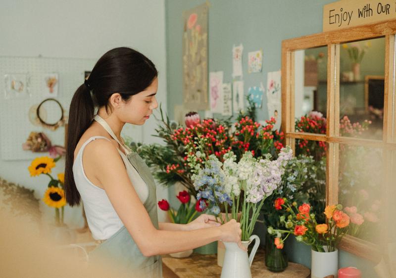Une fleuriste compose un bouquet dans sa boutique